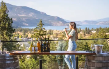 Woman-drinking-wine-with-vineyard-and-valley-background.jpg